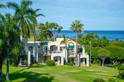 a large white house with the ocean in the background at Palms at Wailea in Wailea