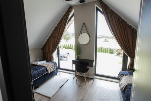 a bedroom with a bed and a desk and a mirror at Domki Pod Łysicą- basen jacuzzi sauna in Krajno Pierwsze