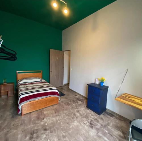 a bedroom with a bed and a green wall at Diaza Rooms Center of Oaxaca in Oaxaca City