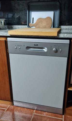 a white dishwasher in a kitchen next to a microwave at Casa da Pracica, Serapicos in Vale de Frades