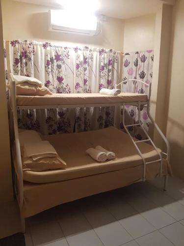 a bunk bed in a room with a curtain at Loidas place in Talisay