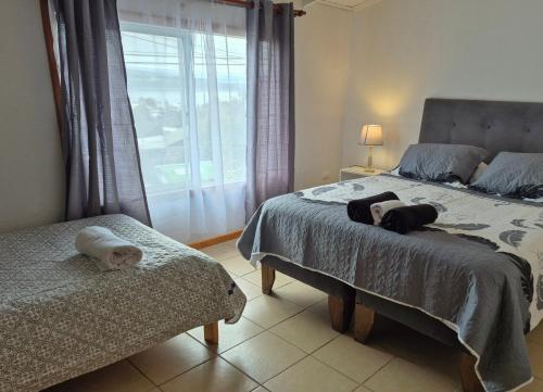 een slaapkamer met een groot bed en een raam bij Departamento bahia fonck in Puerto Montt