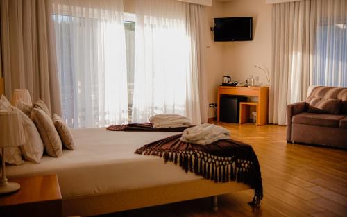 a bedroom with a bed and a large window at Hotel Rural Quinta da Conchada in Aguieira