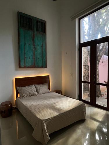 a bedroom with a bed and a large window at Hotelito DELI in Mérida