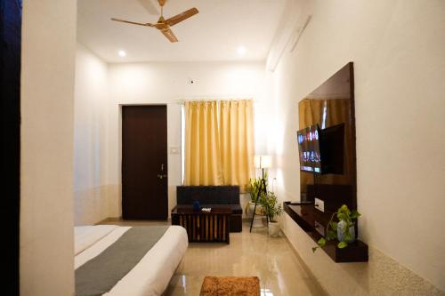 una camera d'albergo con un letto e una tv di Hariom Tatsat Retreat a Pushkar