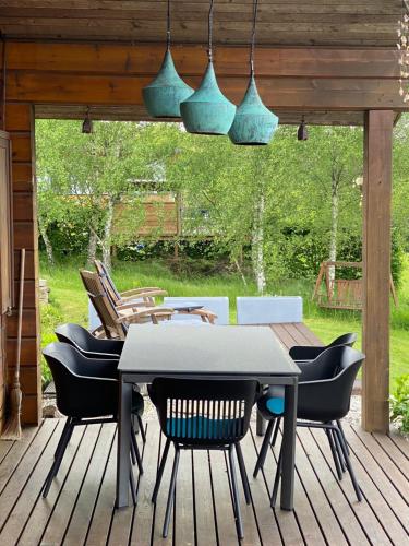 a patio with a table and chairs on a deck at Norwegisches Blockhaus mit Gartensauna in Bad Münstereifel