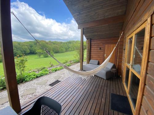 a hammock on the deck of a house at Norwegisches Blockhaus mit Gartensauna in Bad Münstereifel