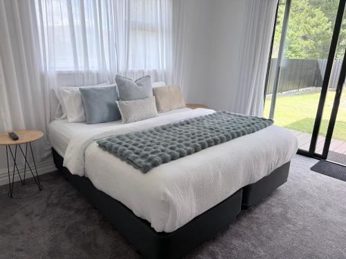 a large bed in a room with a large window at Guesthouse A in Twizel