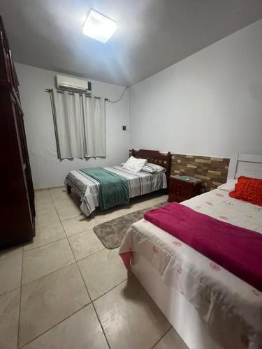 een slaapkamer met twee bedden en een raam bij Casa design Piri no centro de Pirenópolis in Pirenópolis