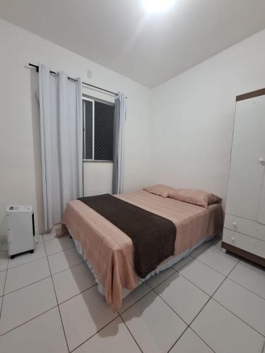 a bedroom with a bed in a white room at Apartamento Condomínio Turu a 6km da Praia in Maioba
