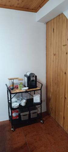 a black shelf with a microwave on it next to a door at Jomafreitas in Ponta Delgada