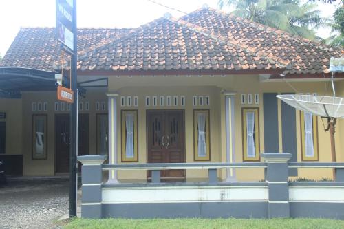 a yellow house with a sign in front of it at Jelajah Batukaras in Batukaras