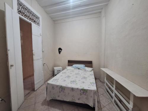 a small white room with a bed and a door at Hostel Canto Zen in Salvador