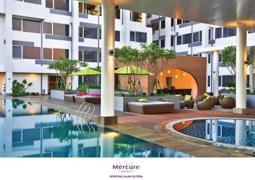 a hotel with a swimming pool in front of a building at Mercure Serpong Alam Sutera in Serpong