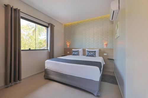 a bedroom with a large bed and a window at Mar e Lar Familia in Maragogi