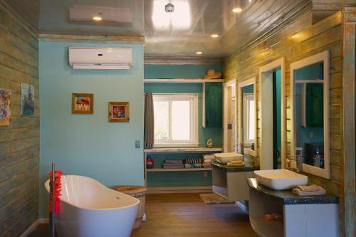 een badkamer met 2 wastafels en een bad bij Skully's House in Bocas del Toro