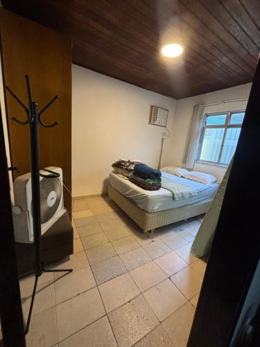 een slaapkamer met een bed en een tv erin bij Casa da Gigi in Arraial do Cabo