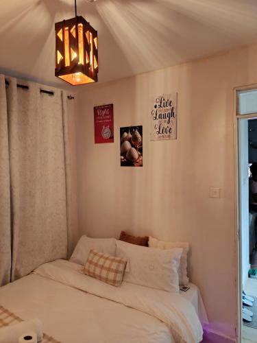 a bedroom with a white bed and a chandelier at EnkishoniBnB Kitengela in Nairobi