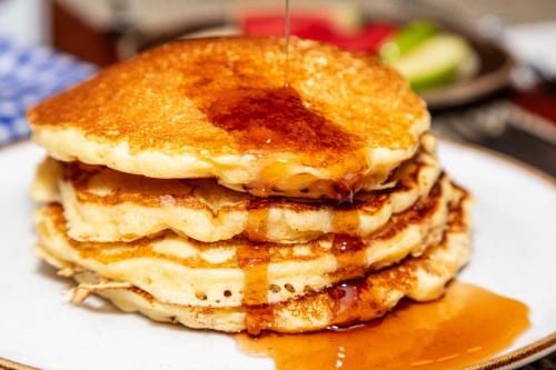 una pila di pancake su un piatto con sciroppo di GHL Hotel Capital a Bogotá