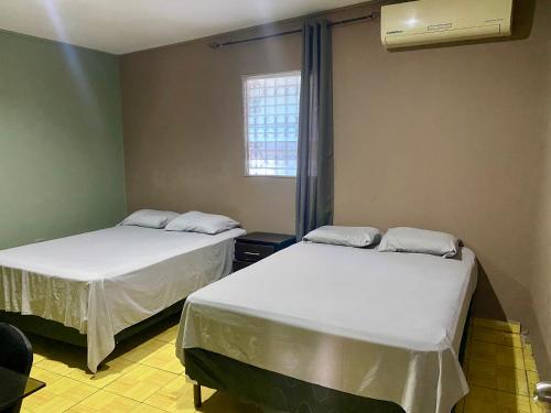 a room with two beds and a window at La Casita in San Pedro Sula
