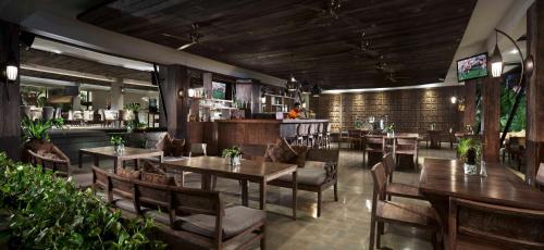 a restaurant with tables and chairs and a bar at Sun Island Hotel & Spa Kuta in Kuta