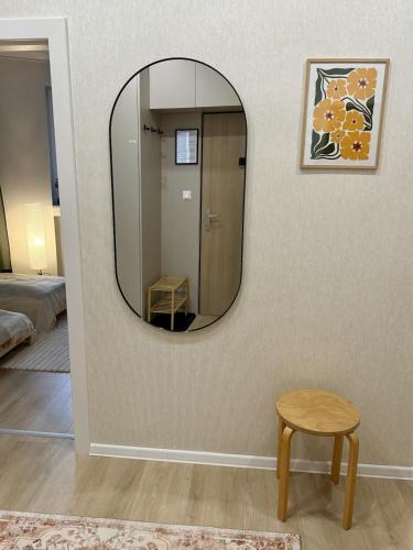 a mirror on a wall in a room with a stool at Bratislava Cozy Corner Apartment in Vinohrady