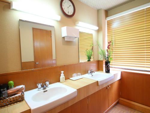 a bathroom with two sinks and a large mirror at Ryokan Kamogawa Asakusa in Tokyo