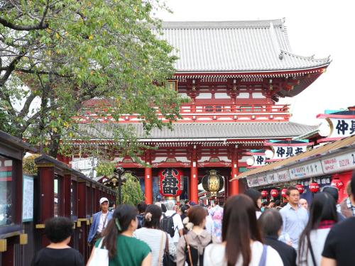 a crowd of people walking in front of a building at Ryokan Kamogawa Asakusa in Tokyo