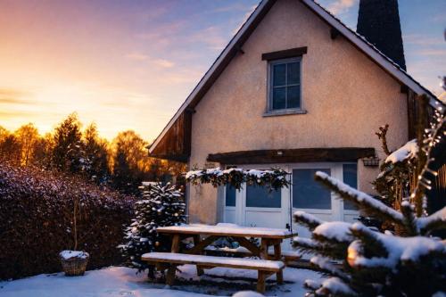a house with a picnic table in front of it at Gite Au Chant d'Eole in Ebly