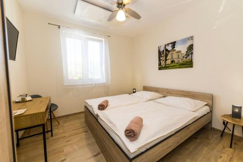 een slaapkamer met een bed, een bureau en een raam bij Comenius Moravus vinařský dvůr in Mikulov