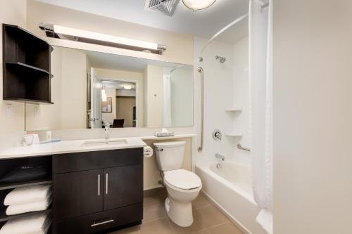 a bathroom with a toilet and a sink and a tub at Park Inn by Radisson, Calgary Airport North, AB in Calgary