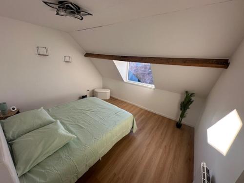 a attic bedroom with a bed and a window at Mad'in Bethune in Béthune