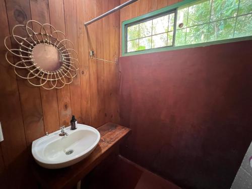 een badkamer met een wastafel, een spiegel en een raam bij Nativa Iguazu in Puerto Iguazú