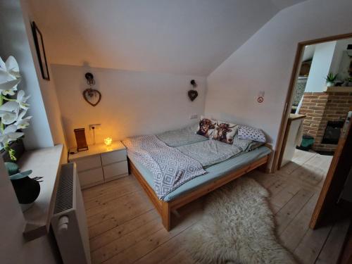 a small bedroom with a bed and a mirror at Domek pod Lasem in Bełchów