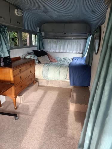 a bedroom with a bed and a desk in a camper at Wharf Street Art in Foxton