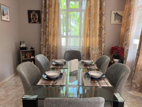 a dining room with a glass table and chairs at House Raghu in Rose Belle