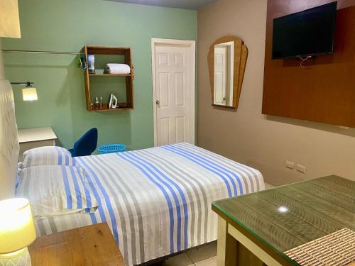 a hotel room with a bed and a television at Mini Suite Apartamento in San Pedro Sula
