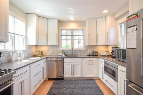 una grande cucina bianca con armadi e elettrodomestici bianchi di Private deck walk to Commercial Street a Provincetown