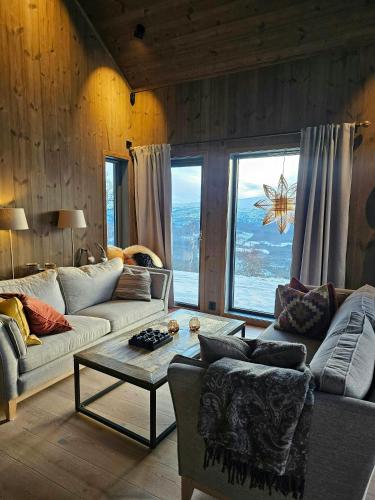a living room with two couches and a table at Mountain Cabin With Panoramic Views And Sauna in Oppdal