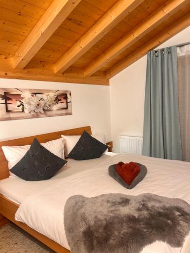 a bedroom with a large bed with a red heart on it at Ferienhaus Happyplace in Illach