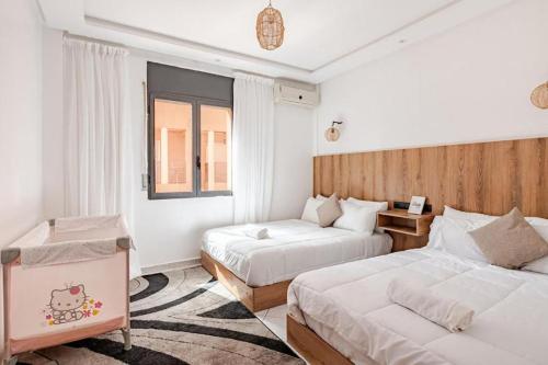 een hotelkamer met twee bedden en een raam bij Modern Elegance & Moroccan Charm - Gueliz Center in Marrakesh