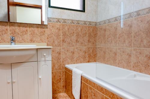 a bathroom with a bath tub and a sink at View to the Valley, By OP in Senhora do Rosário