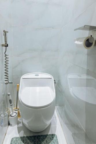 a white bathroom with a toilet and a sink at INEZA SUITEs in Kampala