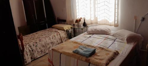 a bedroom with two beds and a window at Casa Ximendes in São Gabriel