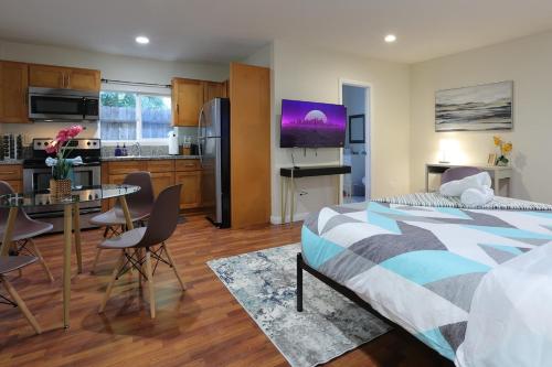 a bedroom with a bed and a kitchen with a table at Modern Oasis Studio - near LAX, SoFi, USC, DTLA in Los Angeles