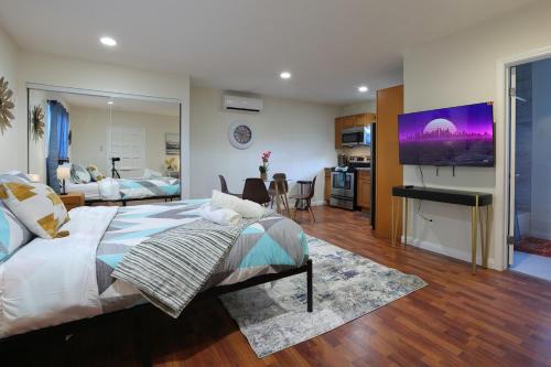 a bedroom with a large bed and a living room at Modern Oasis Studio - near LAX, SoFi, USC, DTLA in Los Angeles