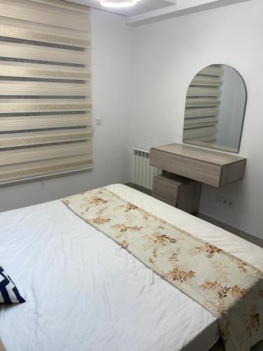 a bedroom with a bed and a mirror at Lux app ain zaghouen in Tunis