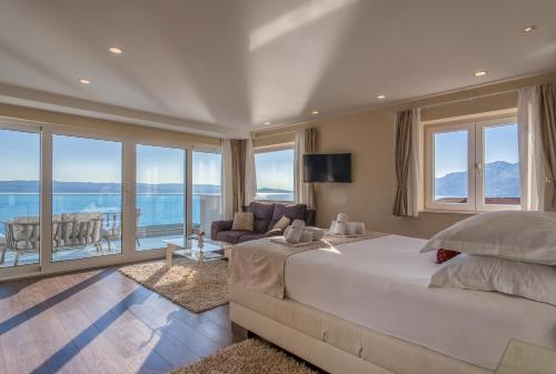 a bedroom with a large bed and a view of the water at Villa Višnja Prestige in Brela