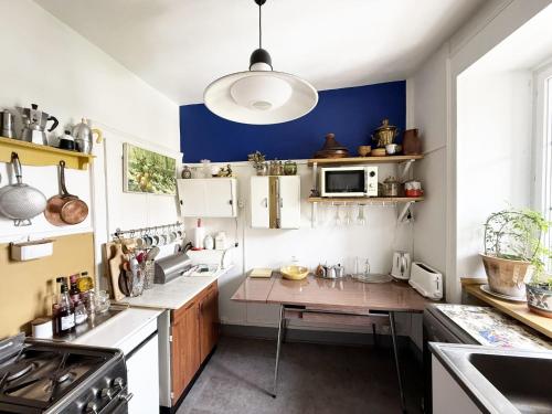 una cucina con banconi bianchi e pareti blu di Très bel appartement en plein centre d'Arbois ad Arbois