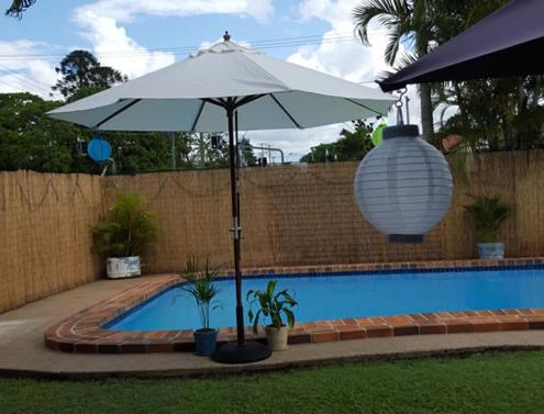 una sombrilla blanca sentada junto a una piscina en Maryborough City Motel, en Maryborough